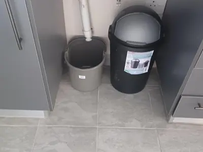 a bathroom with a trash can next to a trash can at Colourfully cosy in Pretoria
