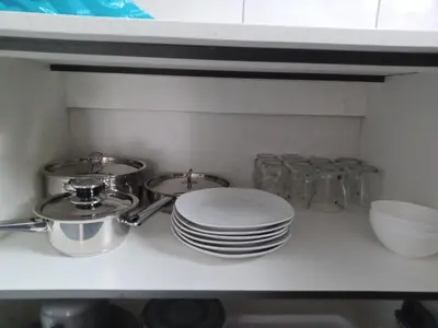 a kitchen counter with plates and dishes on a shelf at Colourfully cosy in Pretoria