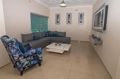 a living room with a couch and a table at Colourfully cosy in Pretoria