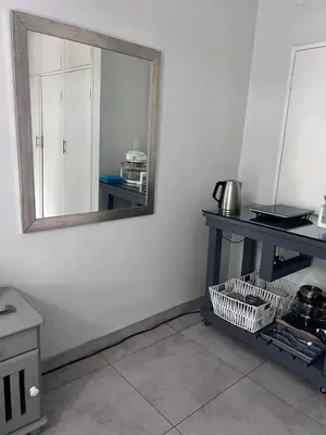 a mirror on a wall in a kitchen with a table at Kuntuala House in Pretoria