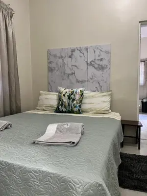 a bedroom with a bed with a towel on it at Kuntuala House in Pretoria