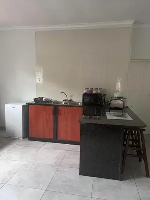 a kitchen with a counter top and a refrigerator at Kuntuala House in Pretoria