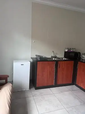 a kitchen with a sink and a white refrigerator at Kuntuala House in Pretoria