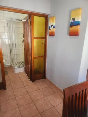 a hallway with a door and a mirror in a room at Kuntuala House in Pretoria
