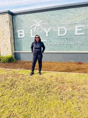 a woman is standing in front of a building at THE BLYDE Holiday Apartments in Pretoria