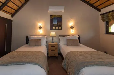 two twin beds in a room with two lamps at Kruger Park Lodge Unit No. 209 in Hazyview