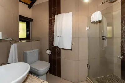 a bathroom with a toilet and a shower at Kruger Park Lodge Unit No. 209 in Hazyview