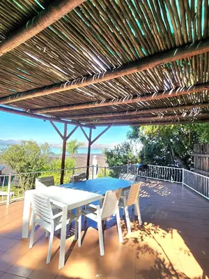 a white table and chairs under a wooden pergola at ScenicViews@103 in Hartbeespoort