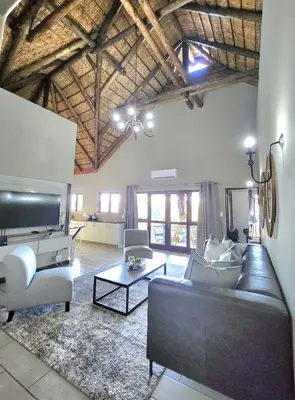 a living room with a couch and a table at ScenicViews@103 in Hartbeespoort
