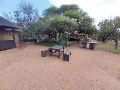 a picnic table and benches in a park at Unathi Game Lodge in Tshwee