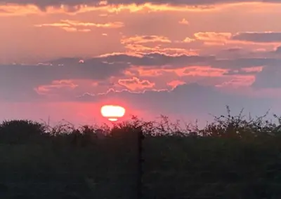 a sunset with the sun in the sky at Unathi Game Lodge in Tshwee