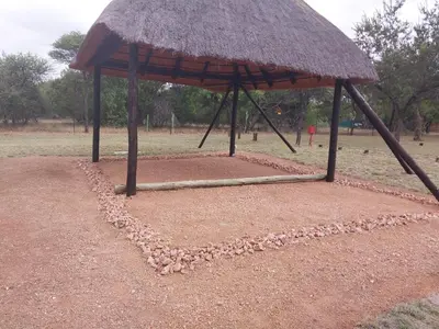 a large umbrella with a bunch of rocks on the ground at Unathi Game Lodge in Tshwee