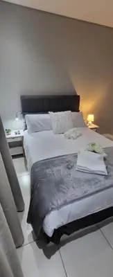a bedroom with a large bed with two towels on it at 801 Guesthouse in Springs