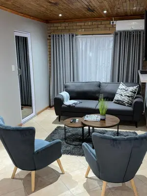 a living room with a couch and a table and chairs at 801 Guesthouse in Springs