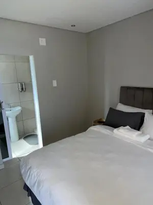 a bedroom with a bed and a bathroom with a sink at 801 Guesthouse in Springs
