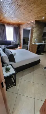 a bedroom with a large bed and a couch at 801 Guesthouse in Springs