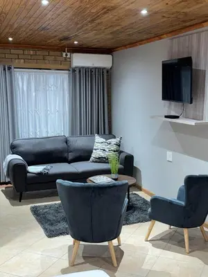 a living room with a couch and two chairs at 801 Guesthouse in Springs