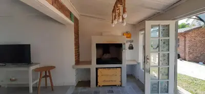 a living room with a fireplace and a tv at Cozy Guest in Graskop