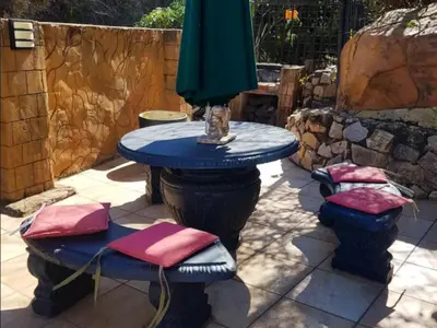 a blue table with pink cushions on a patio at El Shadai Guest House & Spa Hartbeespoort in Hartbeespoort