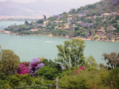 a view of a lake with a boat in the water at El Shadai Guest House & Spa Hartbeespoort in Hartbeespoort