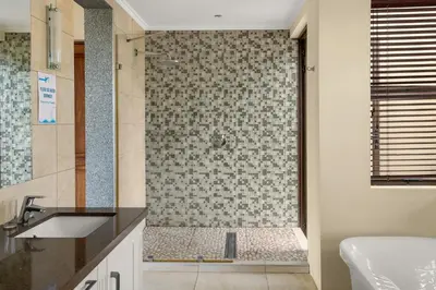 a bathroom with a shower with a sink at Elements Private Golf Reserve House 197 in Bela-Bela