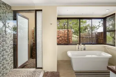 a bathroom with a white tub and a window at Elements Private Golf Reserve House 197 in Bela-Bela