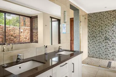 a bathroom with two sinks and a shower at Elements Private Golf Reserve House 197 in Bela-Bela