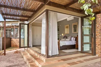 a room with a bed and a glass door at Elements Private Golf Reserve House 197 in Bela-Bela