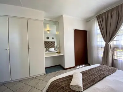 a bedroom with a large bed and a window at Siena Sun Apartment 4 in Midrand