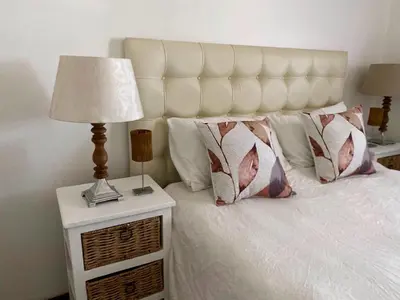 a bedroom with a white bed with a lamp and pillows at Siena Sun Apartment 4 in Midrand