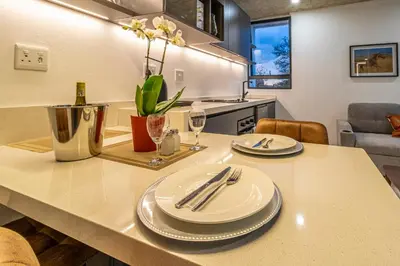 a kitchen with a table with plates and silverware on it at KRAVIT Premier Suites in Midrand