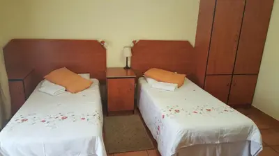 a bedroom with two beds and wooden headboards at Deletz Guesthouse in Witbank
