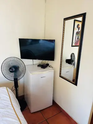 a room with a television on top of a refrigerator at Deletz Guesthouse in Witbank