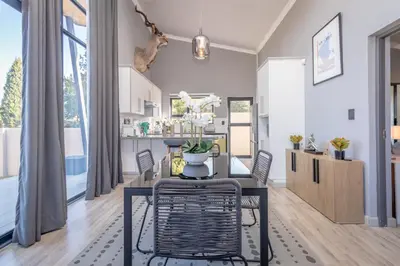 a dining room and kitchen with a table and chairs at Dorpshuis in Dullstroom