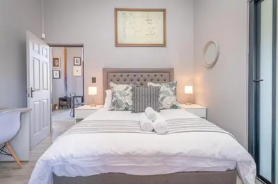 a bedroom with a bed with two white shoes on it at Dorpshuis in Dullstroom