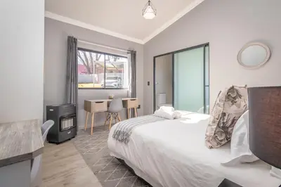 a bedroom with a bed and a tv and a table at Dorpshuis in Dullstroom