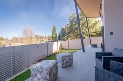 a patio with chairs and a fence and grass at Dorpshuis in Dullstroom