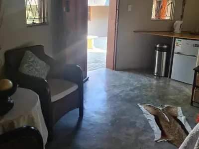 a living room with a chair and a kitchen at Thandolwami Bushlodge in Hoedspruit