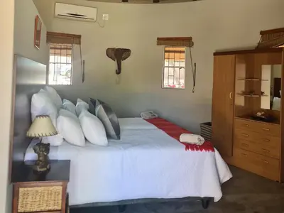 a bedroom with a bed with white sheets and pillows at Thandolwami Bushlodge in Hoedspruit