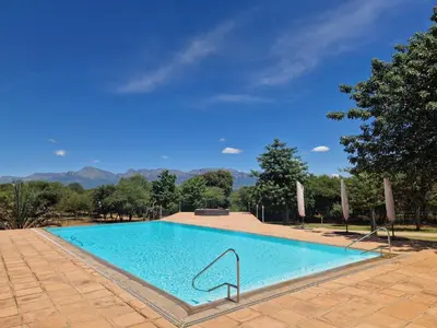 a large swimming pool with a clear blue at Thandolwami Bushlodge in Hoedspruit