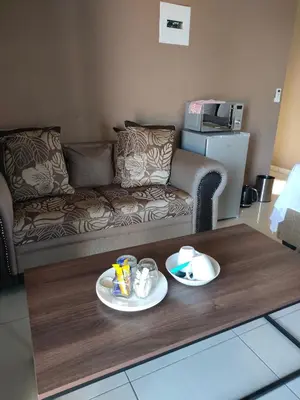 a living room with a couch and a coffee table at Soma Guesthouse in Groblersdal