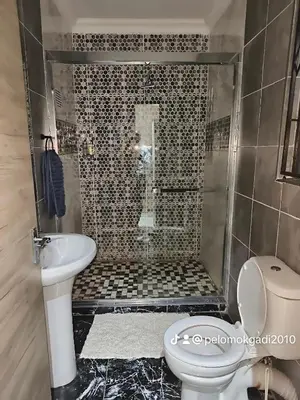 a bathroom with a shower with a toilet and a sink at Soma Guesthouse in Groblersdal