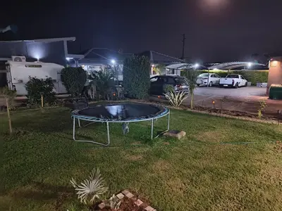 a trampoline in the grass in a yard at night at Soma Guesthouse in Groblersdal