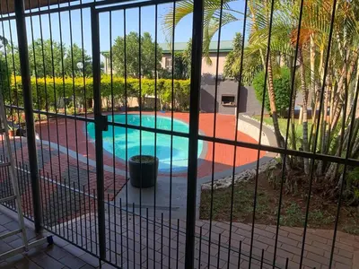a view of a swimming pool through a fence at Victoria guest house Nyumbani in Tzaneen
