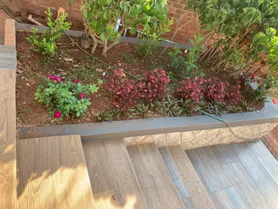 a garden with pink flowers in a stone bench at Victoria guest house Nyumbani in Tzaneen