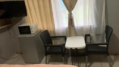 a room with chairs and a table and a television at Victoria guest house Nyumbani in Tzaneen