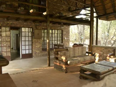 a screened in porch with a couch and a table at Peace of Marloth in Marloth Park