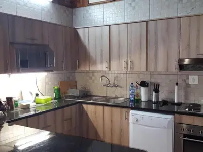 a kitchen with wooden cabinets and a sink at Peace of Marloth in Marloth Park