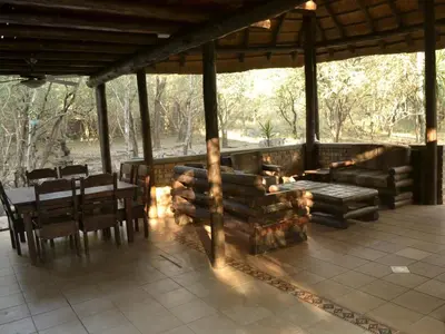 a patio with a table and chairs and a fireplace at Peace of Marloth in Marloth Park