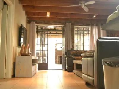 a living room with a couch and a table and a door at Peace of Marloth in Marloth Park